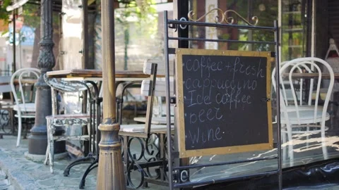 A sidewalk cafe menu board listing available drinks, creating a cozy and in.. Stock Footage 293124378