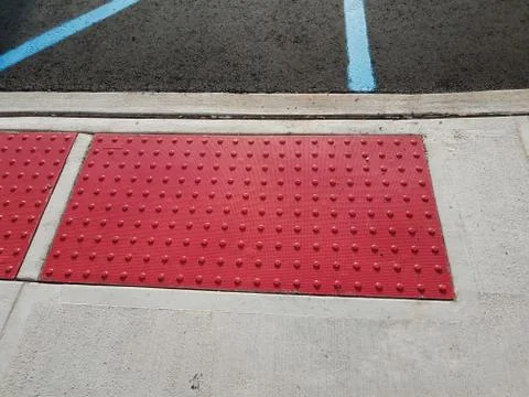Sidewalk cement with red bumpy surface for the blind Stock Photos