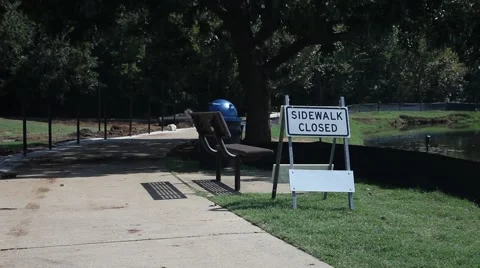 Sidewalk closed around pond at park. Stock Footage 66809352