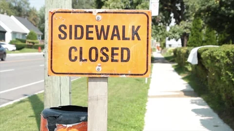 Sidewalk closed writing text orange black horizontal rectangle sign on wood post Stock Footage 252043296