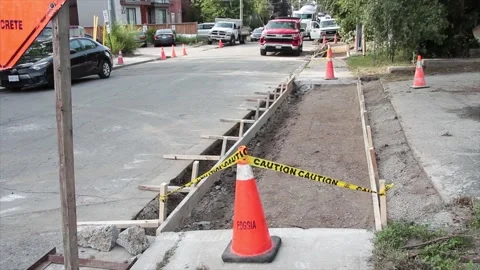 Sidewalk construction building dug out with wood frame and pylons caution tape Stock-Footage 251357079
