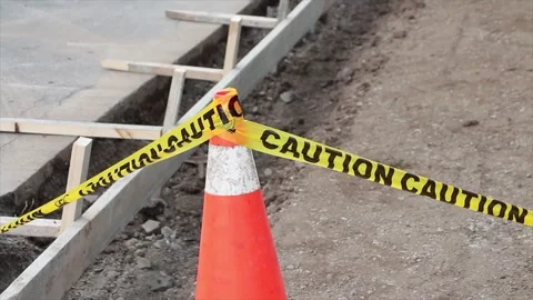 Sidewalk construction building dug out with wood frame and pylons caution tape Stock Footage 251357230