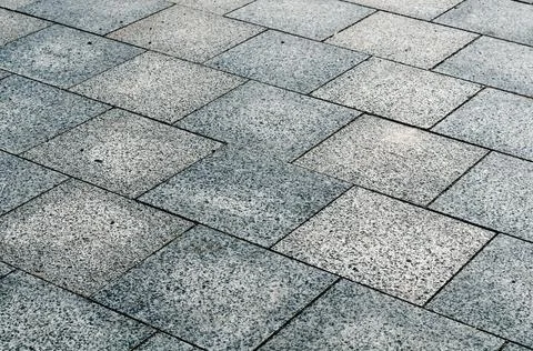 Sidewalk gray square tiles in two shades, laid out diagonally, background Stock Photos