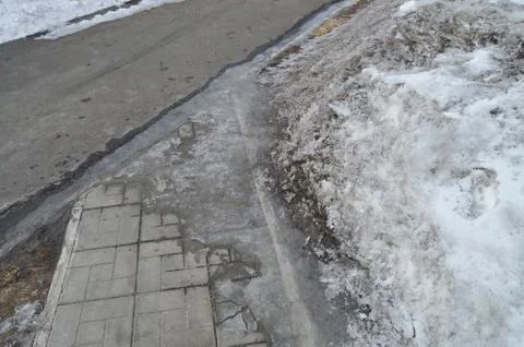 The sidewalk intersection in the Park, the snow on the roadside, spring Stock Photos