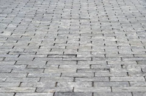 The sidewalk is made of rectangular gray granite bricks . Background Stock Photos