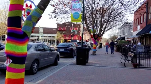 Sidewalk stroll on the square among brightly decorated trees for arts festival 動画素材 174366501