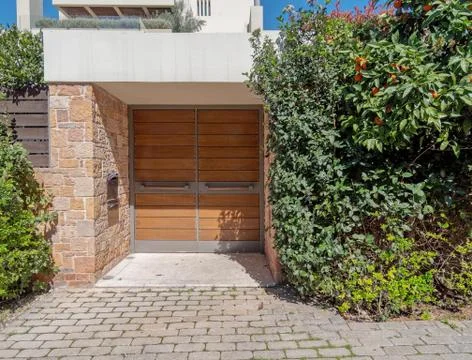 Sidewalk by upscale house entrance solid wooden door and foliage Stock Photos