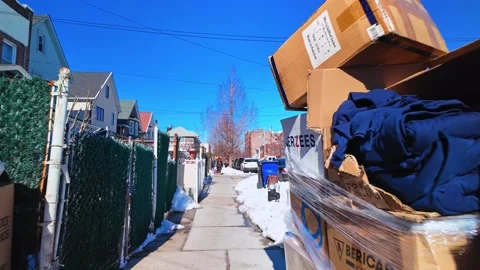 Sidewalk view with stacked cardboard boxes and snow in residential area Stock Footage 329315577