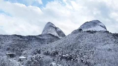 Sideways Aerial Across Snowy Forest and Twin Mountain Peaks at Maisan Stock Footage 344248043