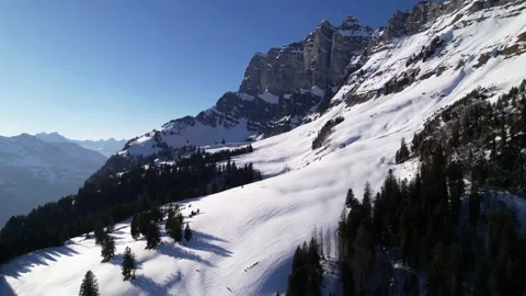 Sideways aerial flight over remote snowy winter mountain landscape panorama Stock Footage 170485589