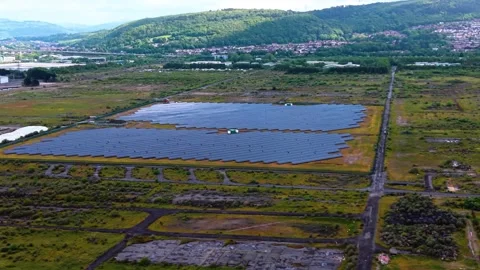 Sideways Aerial of Modern Solar Panel Array with Houses and Hill in Background Stock Footage 336017078
