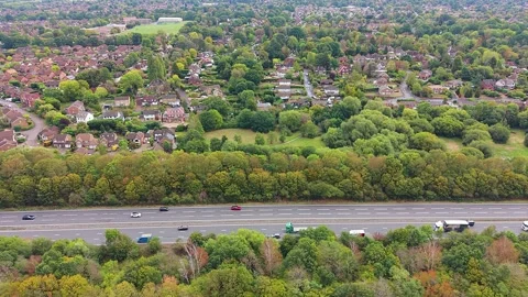 Sideways Aerial Over Busy Highway with Suburban Houses in Surrey, UK. Stock Footage 346751128