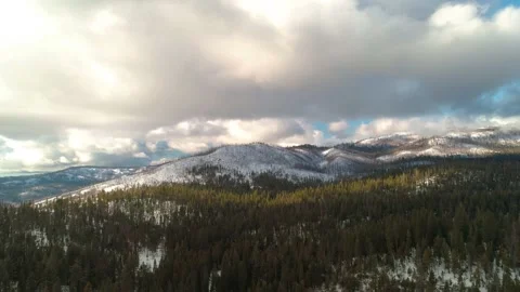 Sideways aerial over epic winter landscape. Snowy mountains, beautiful clouds. 库存影片 148719963
