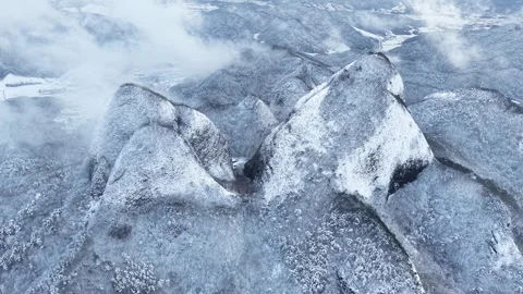 Sideways Aerial of Snow-Covered Mountain with Fast-Moving Clouds Stock Footage 344248161