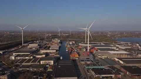 Sideways aerial view of wind turbines and industrial port Stock Footage 335658594