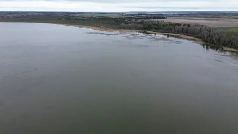Sideways drone flight along a moody riverbank on an overcast day Stock Footage 312417708