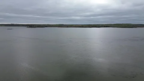 Sideways drone flight over a moody lake with cloud reflections. Stock Footage 312417099