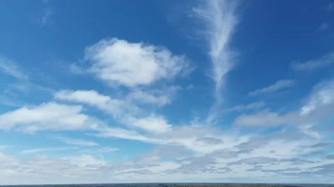 Sideways drone flight through a beautiful blue sky with white clouds Stock Footage 312417866