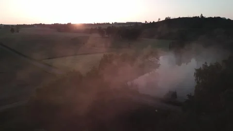 Sideways Drone Flight Through Morning Mist Over Pond with Sun Rays Stock Footage 311330106