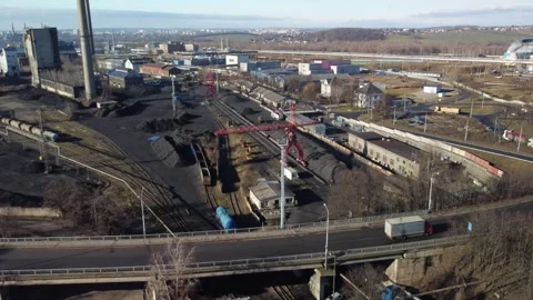 Sideways drone movement captures a crane loading material onto a truck at an Stock Footage 343020478