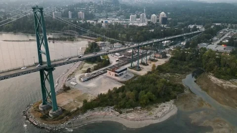 Sideways flight across Lions Gate bridge at dusk 動画素材 248480661