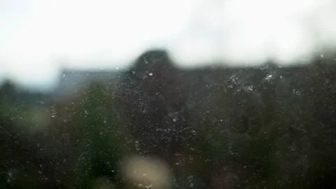 Sideways move across dirty window pane, trees/houses in background Stock Footage 245912443