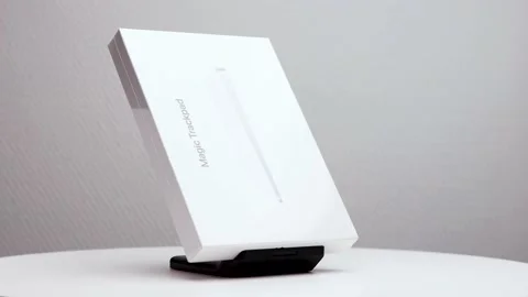 Sideways shiny white package box of Mac magic trackpad on display stand Stock Footage 176443823