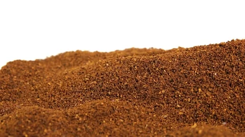 Sideways tracking shot of mounds of ground coffee against white background Stock Footage 64353730