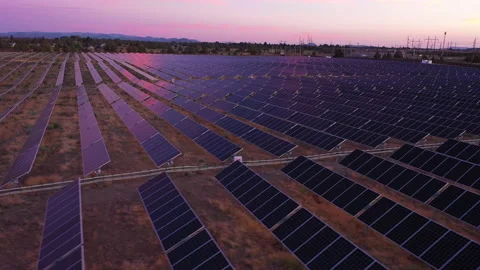 Sideways tracking shot over solar panels with gorgeous pink and purple sky Stock Footage 160931921