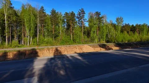 A sideways view to the right with a smooth left pan over a newly paved road.. Stock Photos