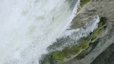 Sideways view of waterfall in slow motion over mossy cliff face in Great Falls Stock Footage 91902711