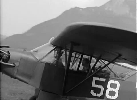 SIEGEN, GERMANY - 1945: Aircraft arrival - Officers greet beside liaison plane Stock Footage 344488758