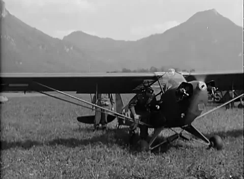 SIEGEN, GERMANY - 1945: Airfield arrival - Soldiers approach a liaison plane Stock Footage 344488761