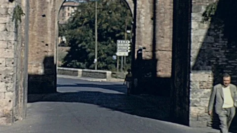 Siena 1958: man walks in front of a Medieval gate Stock Footage