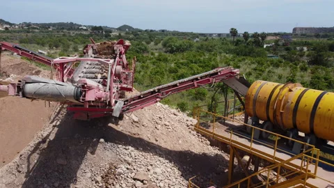A sieving machine classifying aggregates and dumping in a trommel to wash it Video stock 196890319