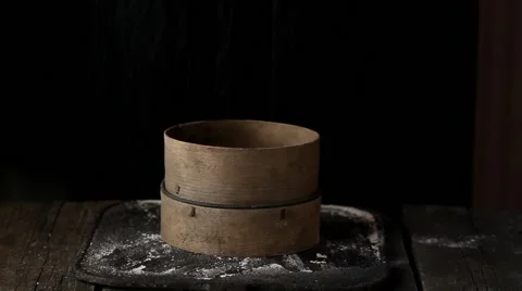 Sieving whole wheat flour through old sieve by woman's hands. Dark rustic style Stock Footage 58571167