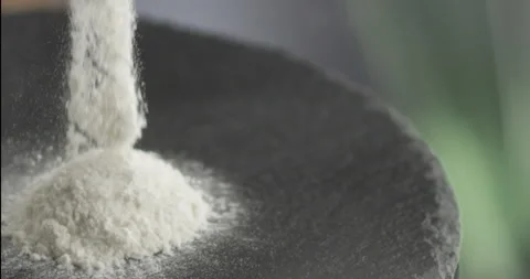 The sifted flour begins to fall on the hill of flour Stock Footage 199023652