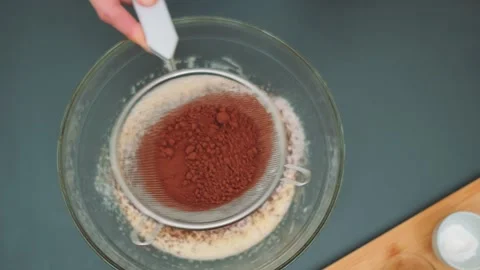 Sifting dark cocoa into a deep plate Stock-Footage 252466036