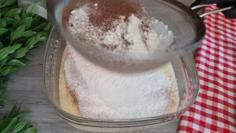 Sifting Flour and Cocoa Powder into Cake Batter - Chocolate Cake Preparation Stock Footage 346523005