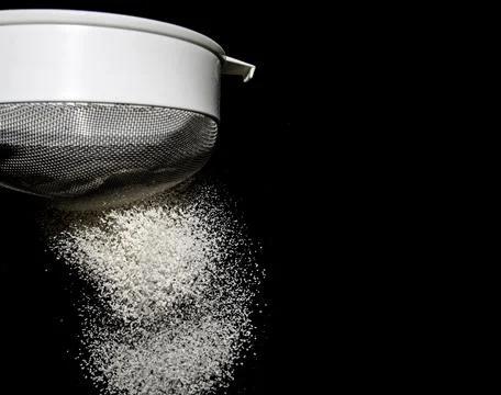 Sifting Flour on Black Background Stock Photos