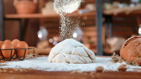 Sifting flour on raw dough for bread in kitchen of bakery, close-up view on Video stock 266443729