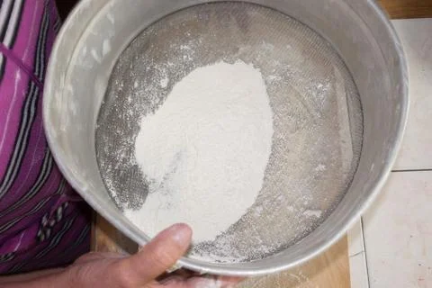 Sifting the flour in a sieve. Stock Photos