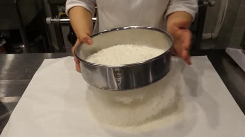 Sifting Flour through a Metal Sifter onto a White Surface Video stock 345291527