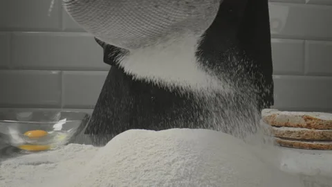 Sifting flour through a sieve. The flour is sifted through a sieve. Stock Footage 154997387
