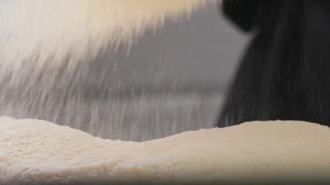 Sifting flour through sieve. Grey background. Hands throws dry flour, falling Stock Footage 271294755