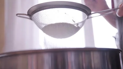 Sifting flour through a sieve into a large bowl. Preparing the dough. Stock Footage 271457047