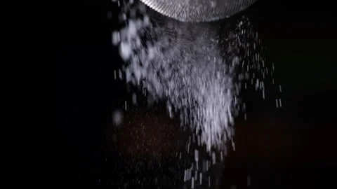 Sifting icing sugar in slow motion on dark background Video stock 155890673