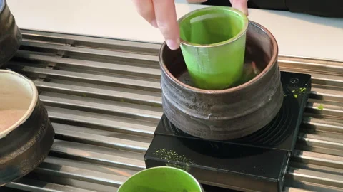 Sifting matcha powder through a sieve into a teacup Stock Footage 288452916