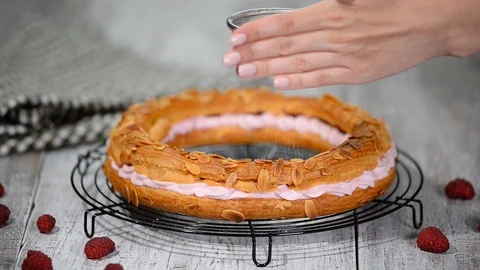 Sifting powdered sugar over a paris brest. Stock Footage 93928406