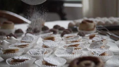 Sifting powdered sugar on the table with leaf alfajores, homemade atmosphere Stock Footage 243188553